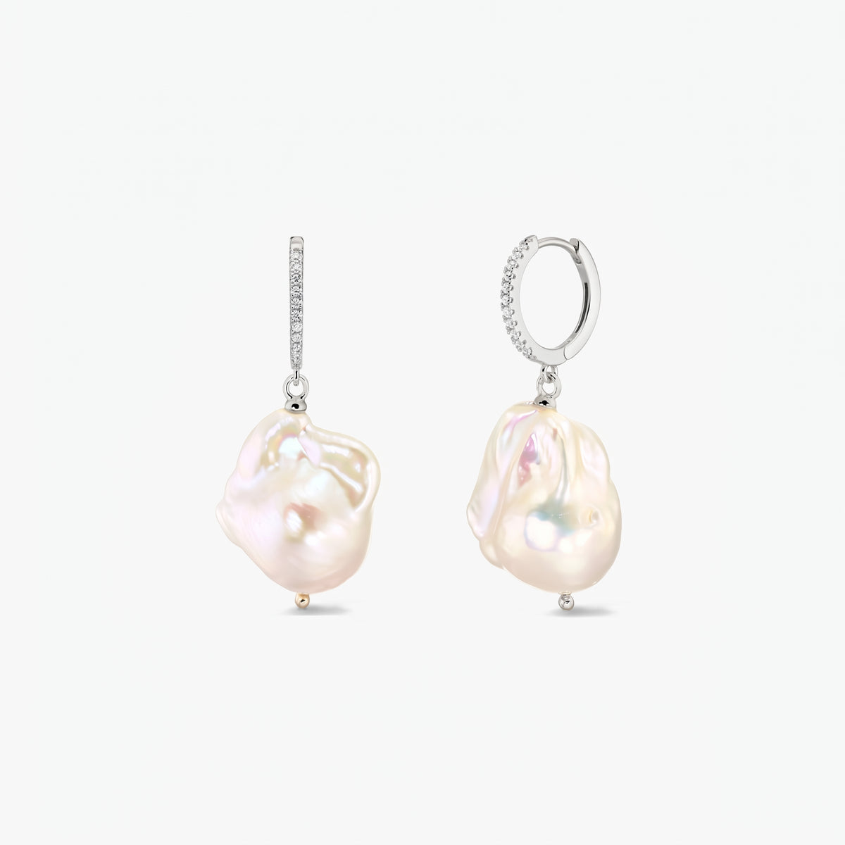 Pair of rhodium‑plated 925 silver hoop earrings with pavé zirconia and large organic baroque pearls on a white background.