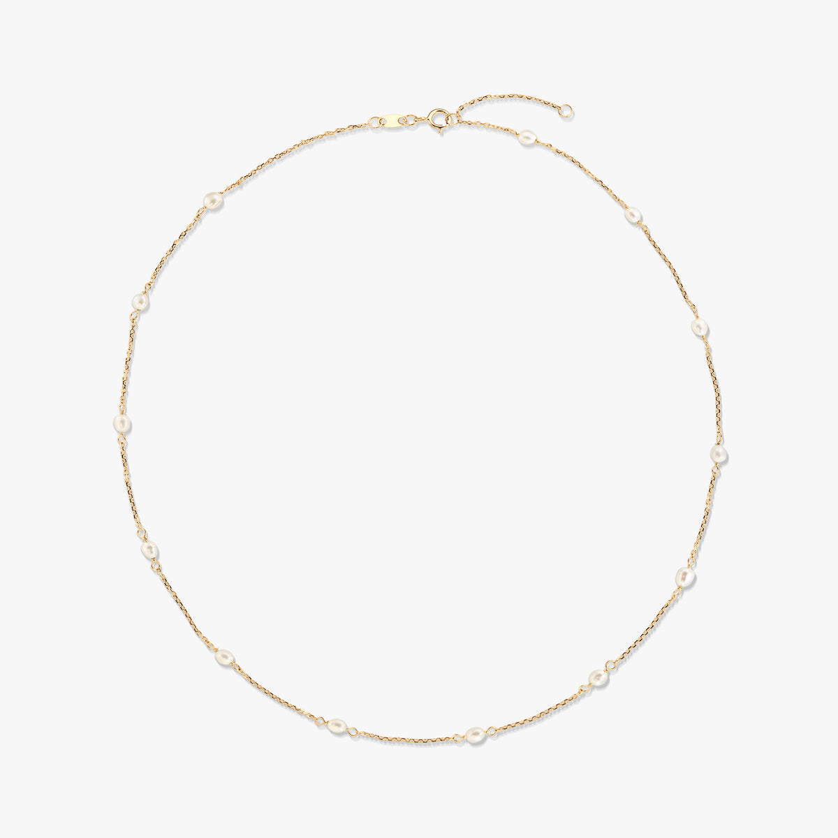 14K yellow gold station necklace with small natural white pearls spaced along a fine chain, isolated on a white background.