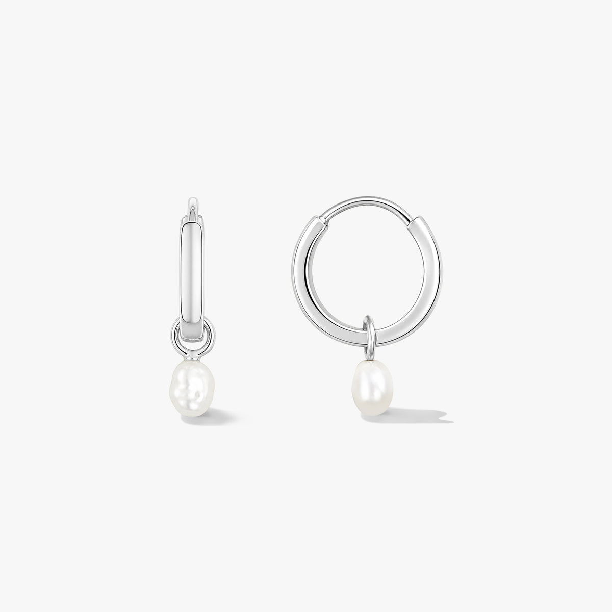 Pair of sterling silver hoop earrings with small natural pearl drops on a white background, one shown front-facing and one in side view.