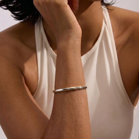 A close-up of a person wearing a Serena Silver Bracelet on their arm, against a plain background.
