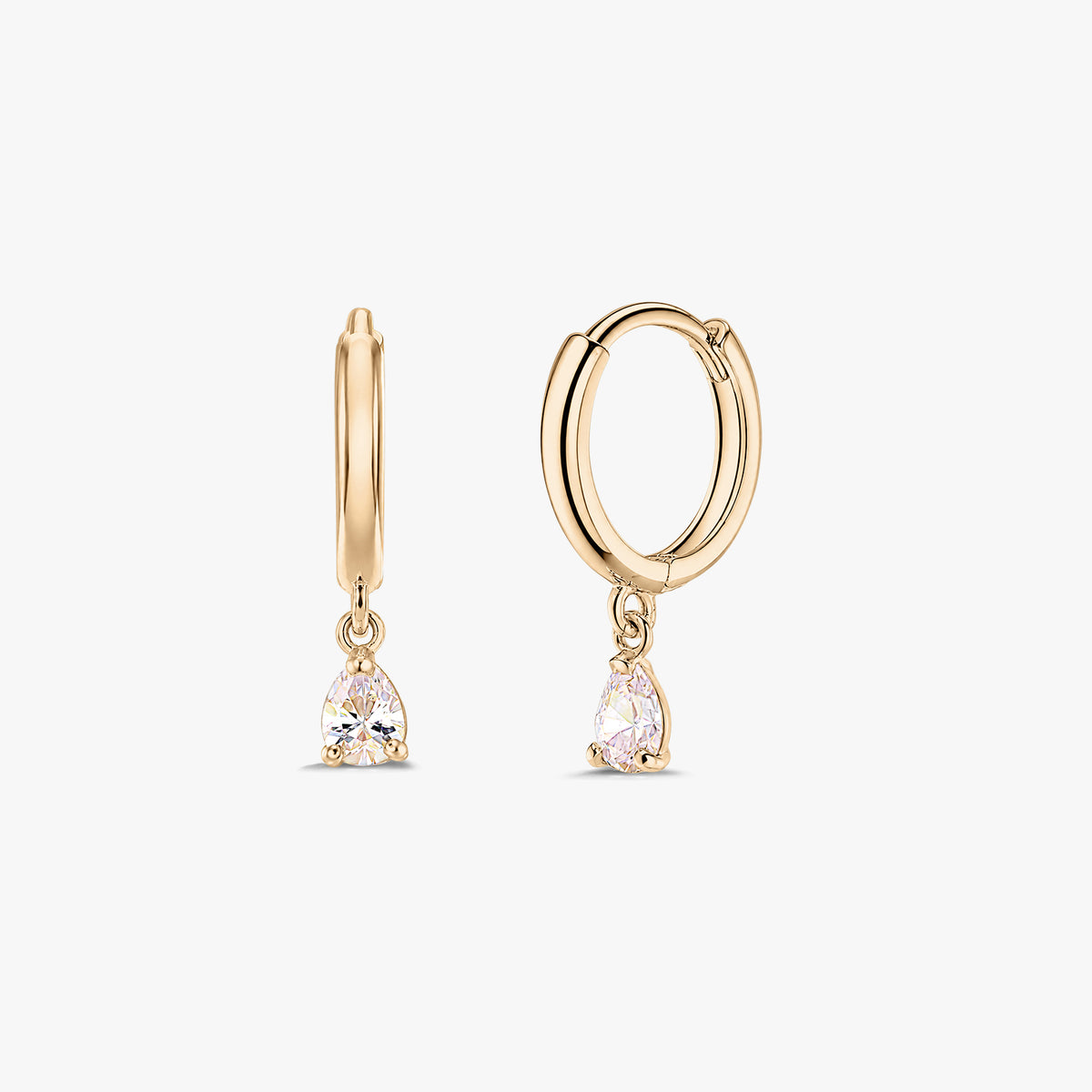 Pair of 14K yellow gold huggie hoop earrings with dangling pear-cut white zirconia drops on a white background.