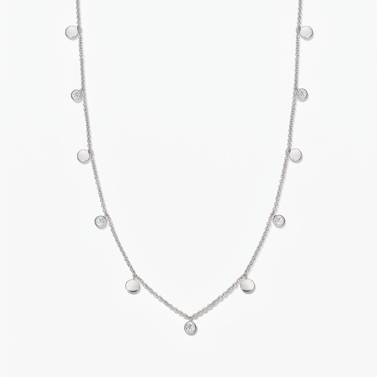 Sterling silver Noora station necklace with alternating polished discs and bezel‑set white topaz stones on a white background.