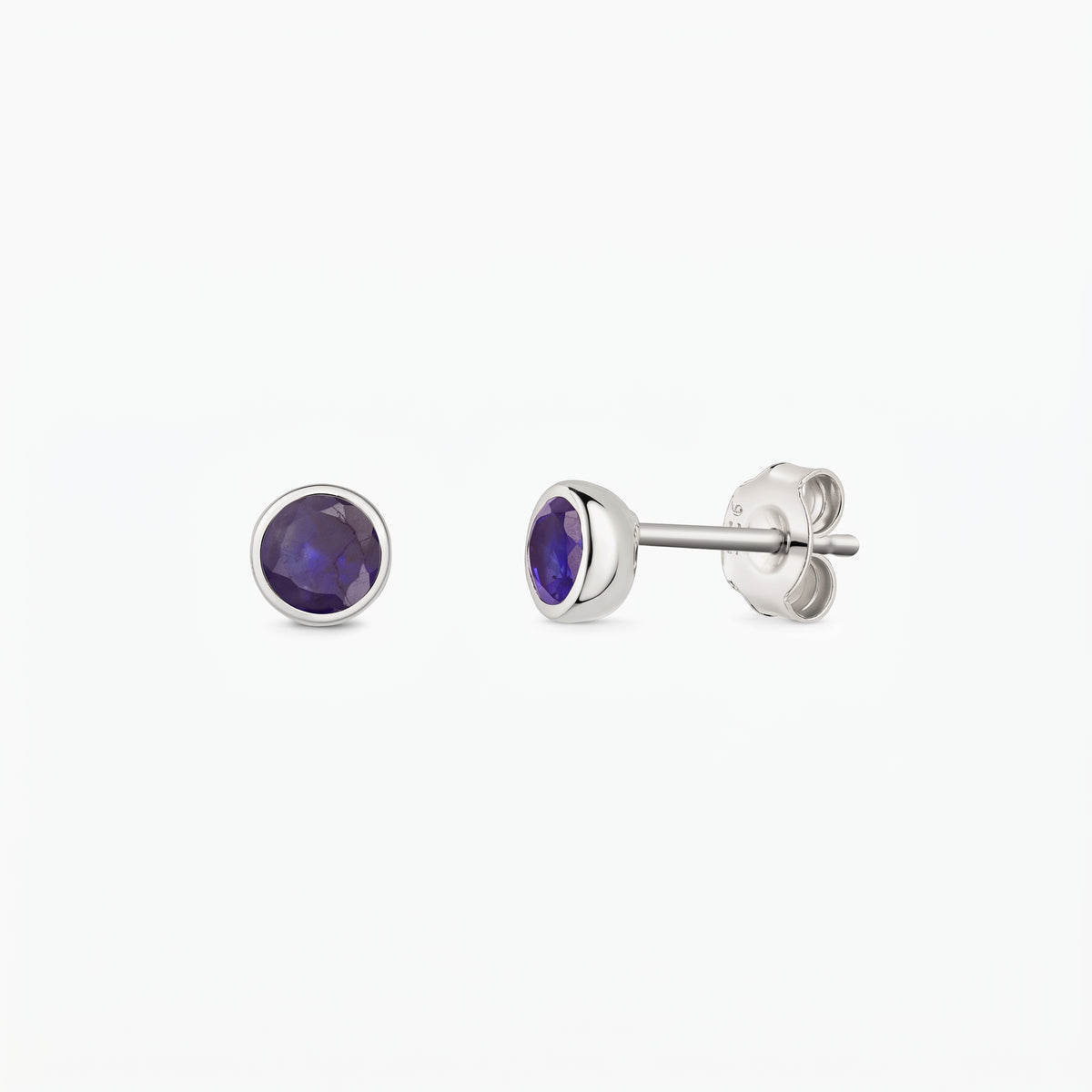 Silver bezel-set sapphire stud earrings, shown front and side on a white background.