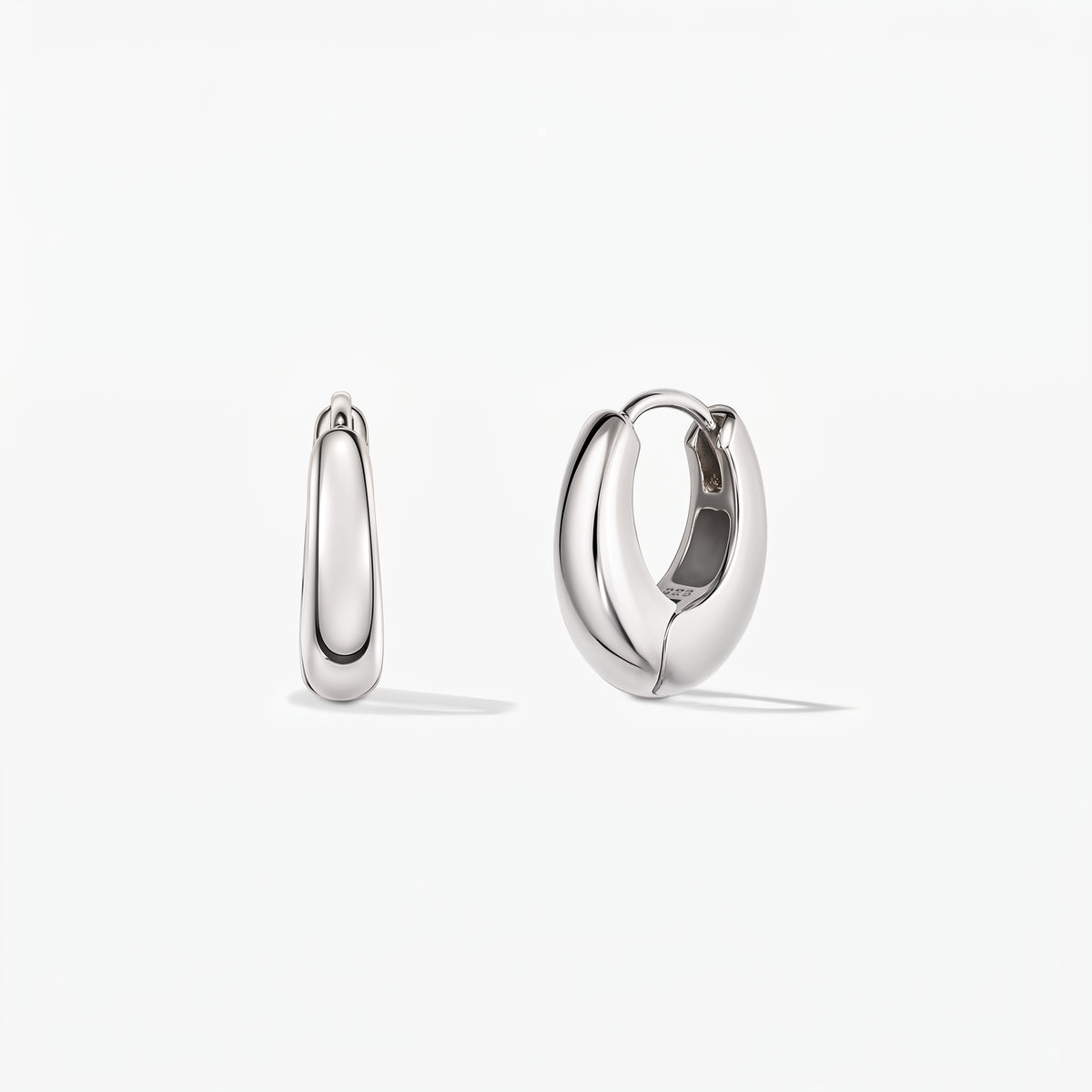 Pair of polished mini dome silver huggie hoop earrings on a white background, shown in front view and one open to reveal the hinged clasp.