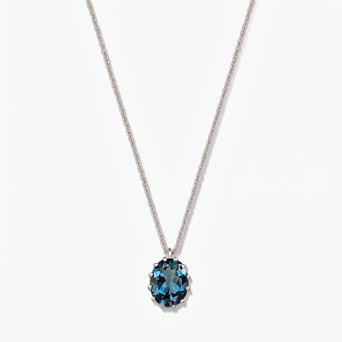 Sterling silver necklace with an oval London blue topaz pendant on a white background.
