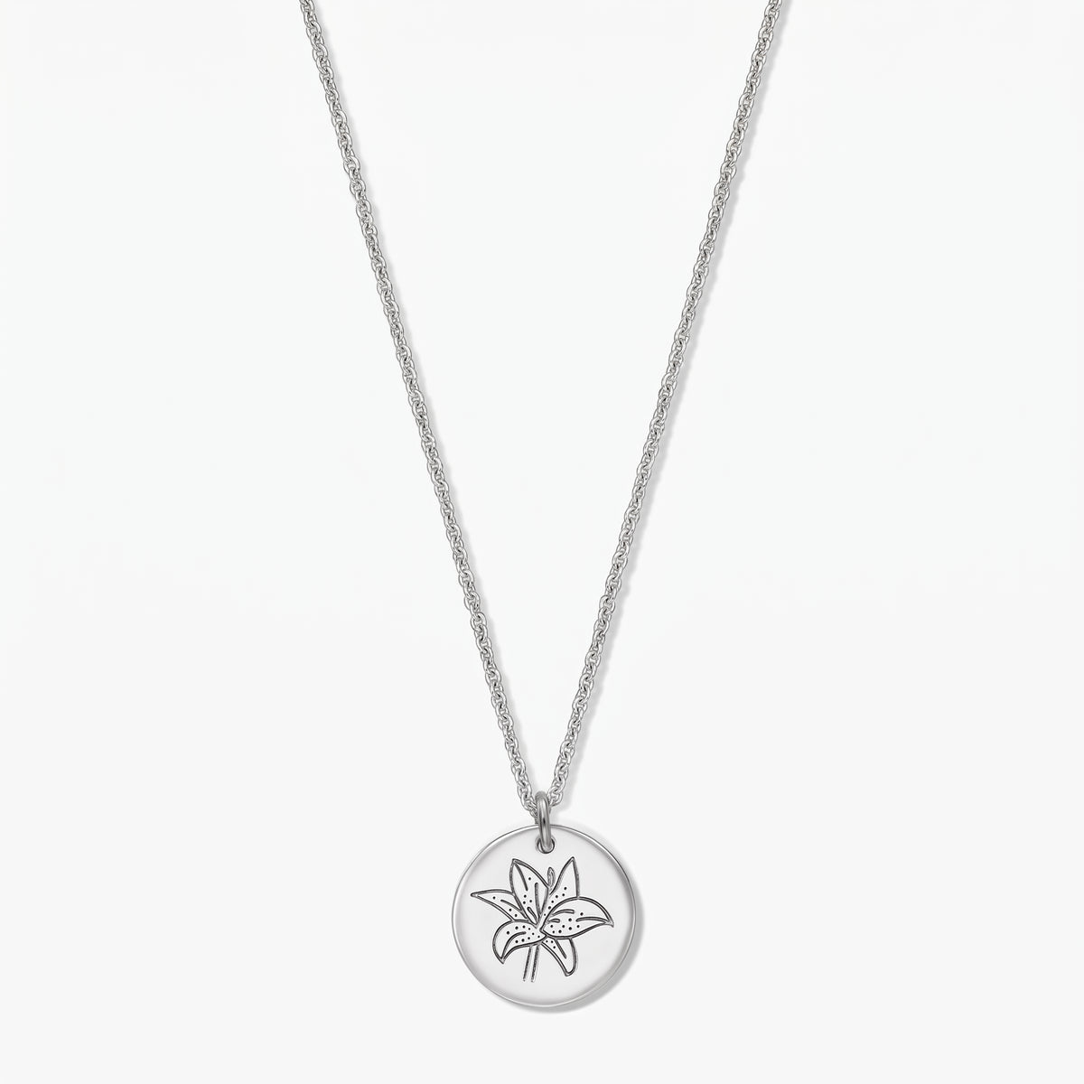 Sterling silver birthflower necklace with a round disc pendant engraved with a lily (May), shown on a white background.