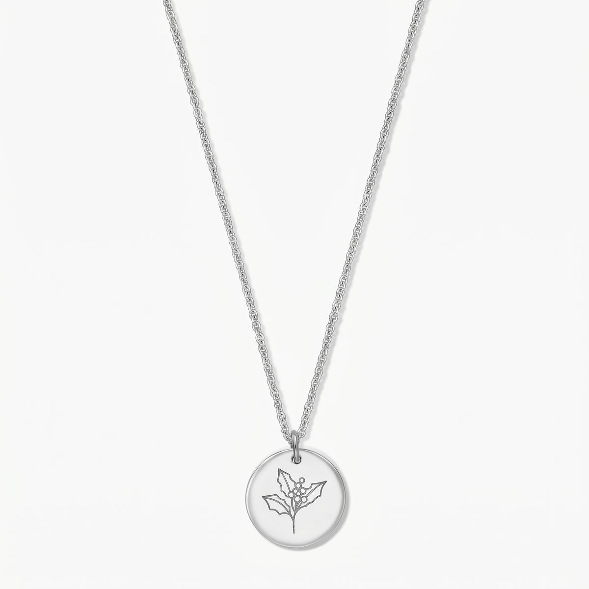 Sterling silver birthflower necklace with a round pendant engraved with a holly sprig, shown on a white background.