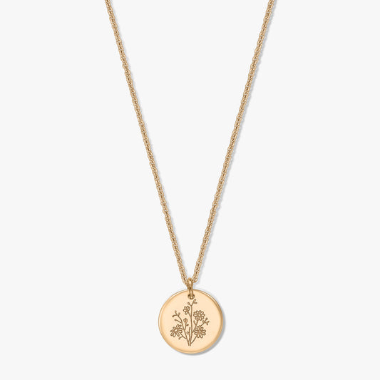 Gold-plated silver necklace with a delicate rope chain and round coin pendant engraved with an aster birthflower, isolated on a white background.