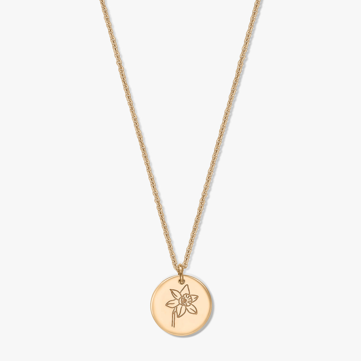 Gold‑plated silver necklace with a round disc pendant engraved with a March daffodil, photographed on a white background.