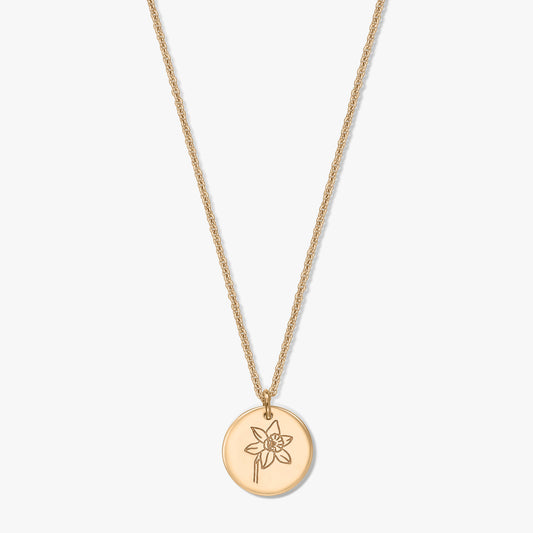 Gold‑plated silver necklace with a round disc pendant engraved with a March daffodil, photographed on a white background.