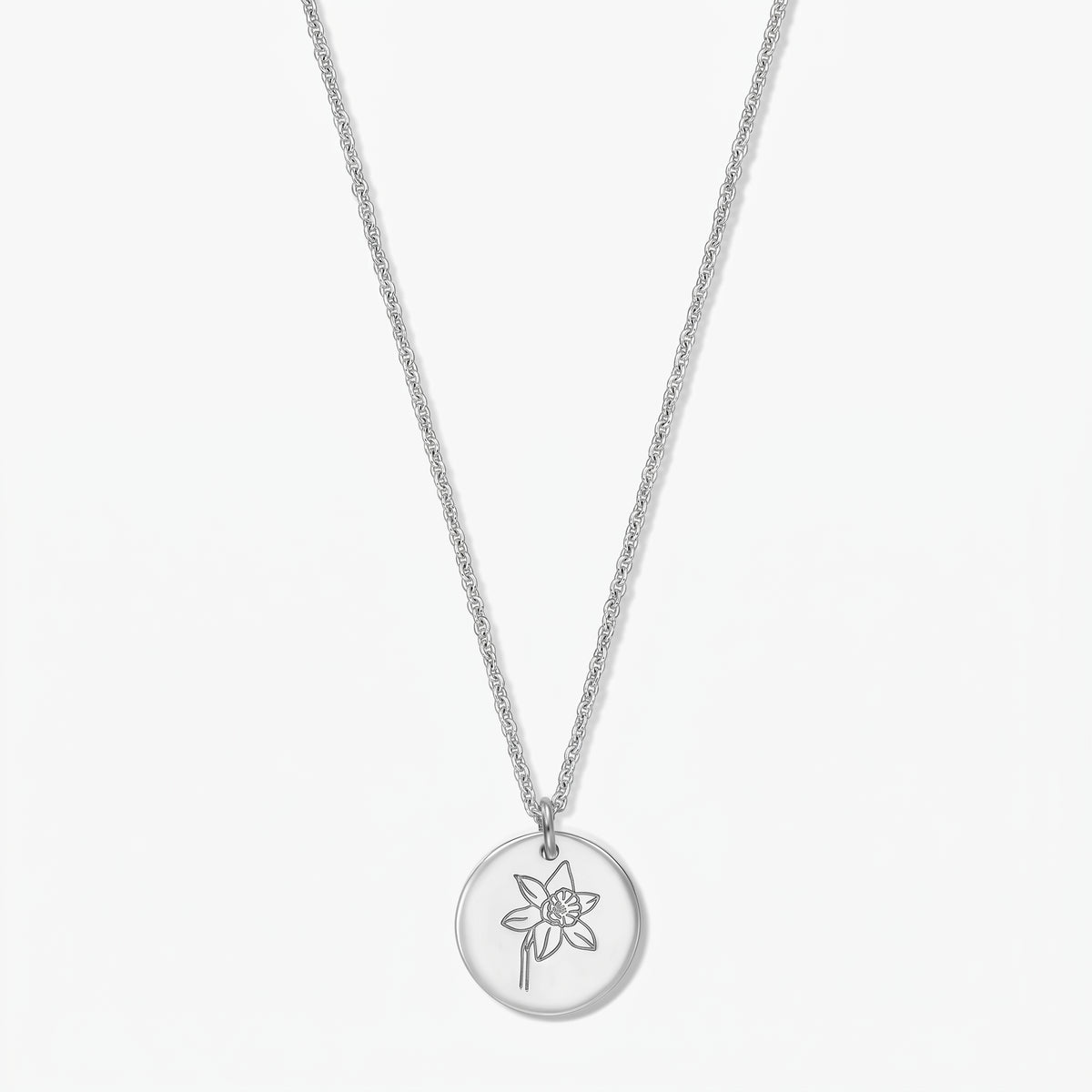 Sterling silver necklace with a round pendant engraved with a daffodil (March birth flower) on a white background.