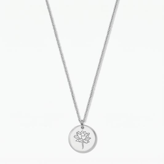 Sterling silver birthflower necklace with a round disc pendant engraved with a lotus (July), photographed on a white background.