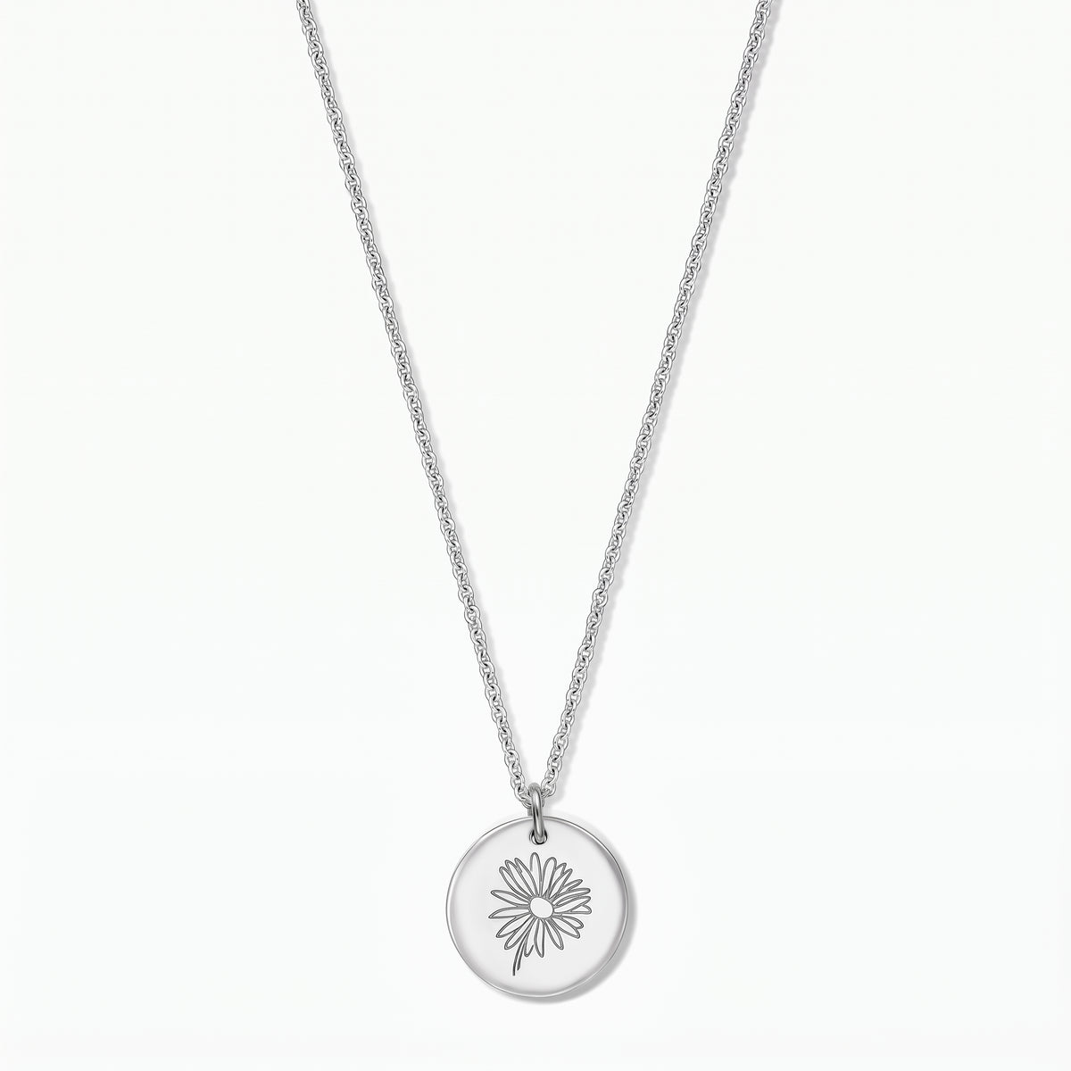 Sterling silver necklace with a round disc pendant engraved with a daisy, photographed on a white background.