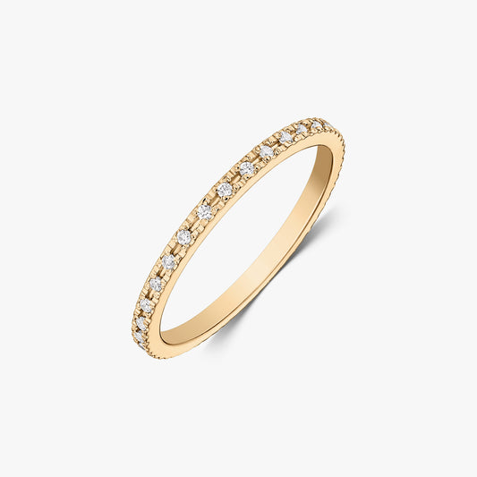 Slim tennis wedding band in 14K yellow gold with pavé-set white zirconia stones, photographed on a white background.
