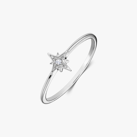 Dainty sterling silver ring with a star-shaped setting holding a white zirconia stone, photographed on a white background.