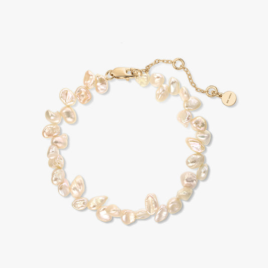 Gold‑plated sterling silver bracelet with natural pink keshi pearls and extender chain on a white background.