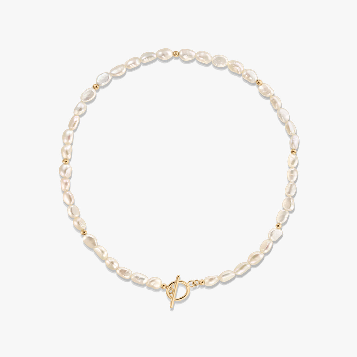Studio photo of a natural pearl beaded necklace with small gold spacer beads and a gold-tone toggle clasp, arranged in a circle on a white background.