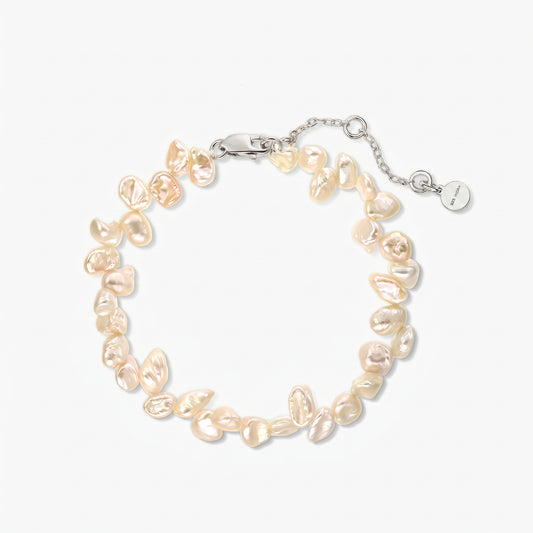 Square studio photo of a rhodium‑plated silver bracelet strung with irregular pink keshi freshwater pearls, shown in a circle on a white background with an adjustable chain and lobster clasp.