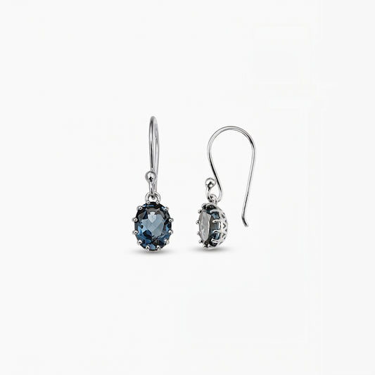 Pair of sterling silver drop earrings with oval London blue topaz gemstones on a white background.