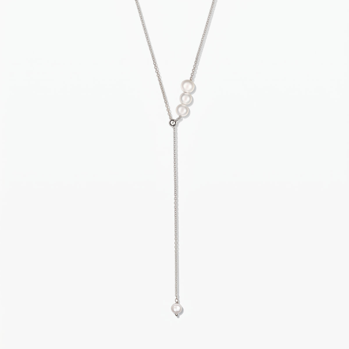 Adjustable sterling silver lariat necklace with white cultured pearls, centered on a white background.