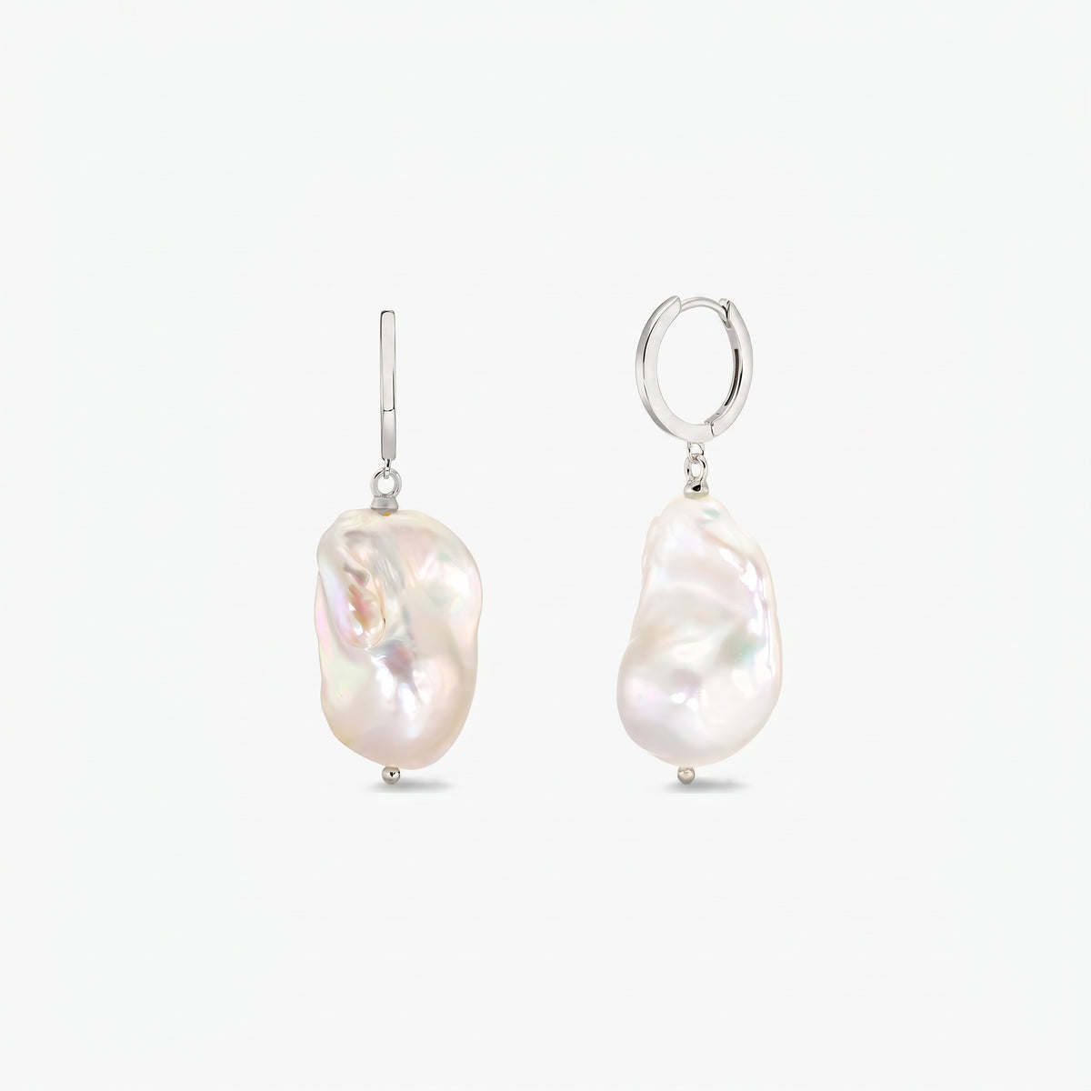 Pair of sterling silver hoop earrings with large irregular baroque white pearls on a clean white background.
