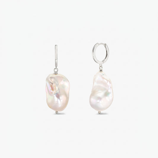 Pair of sterling silver hoop earrings with large irregular baroque white pearls on a clean white background.