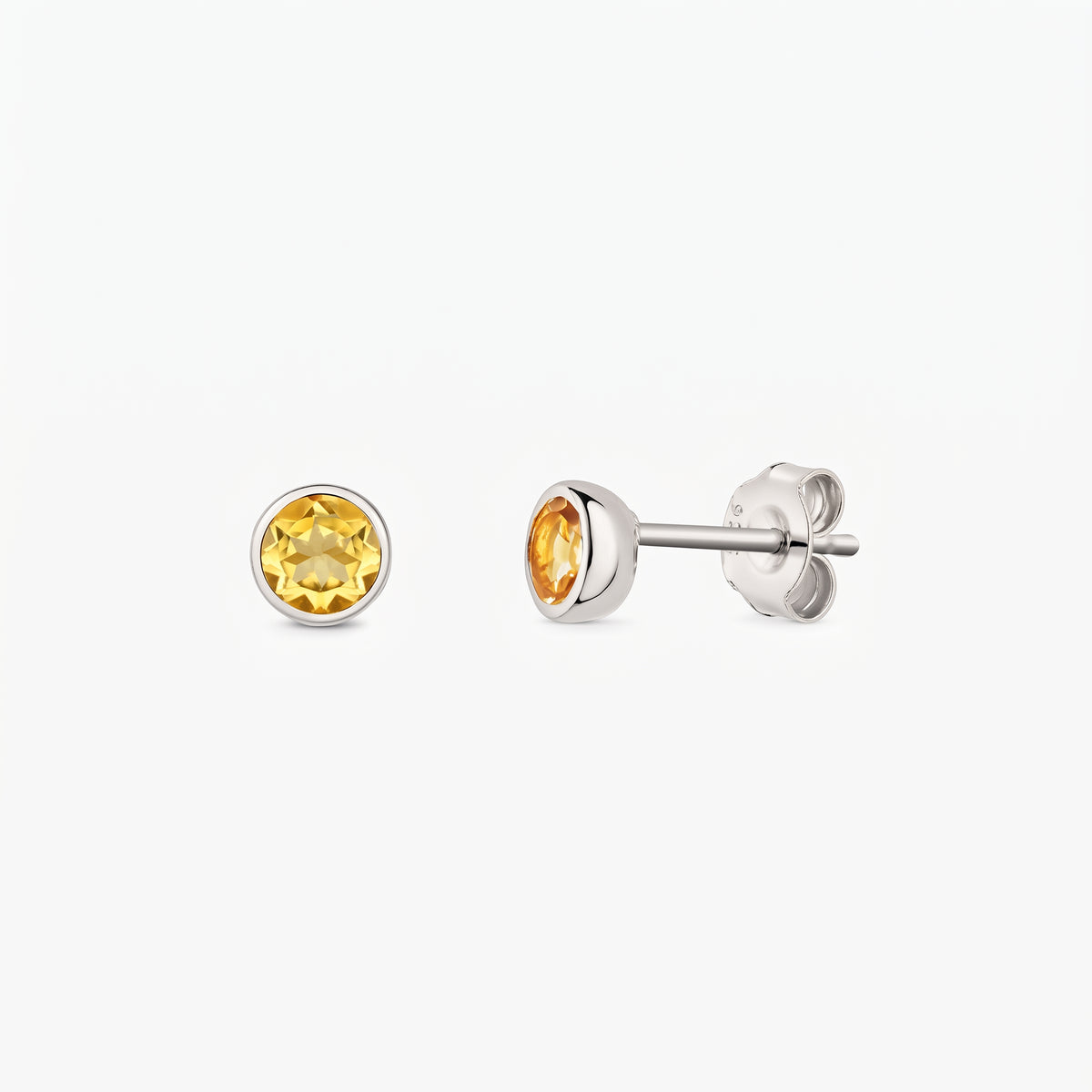 Silver stud earrings with round citrine birthstones on a white background, shown front and side with butterfly backs.