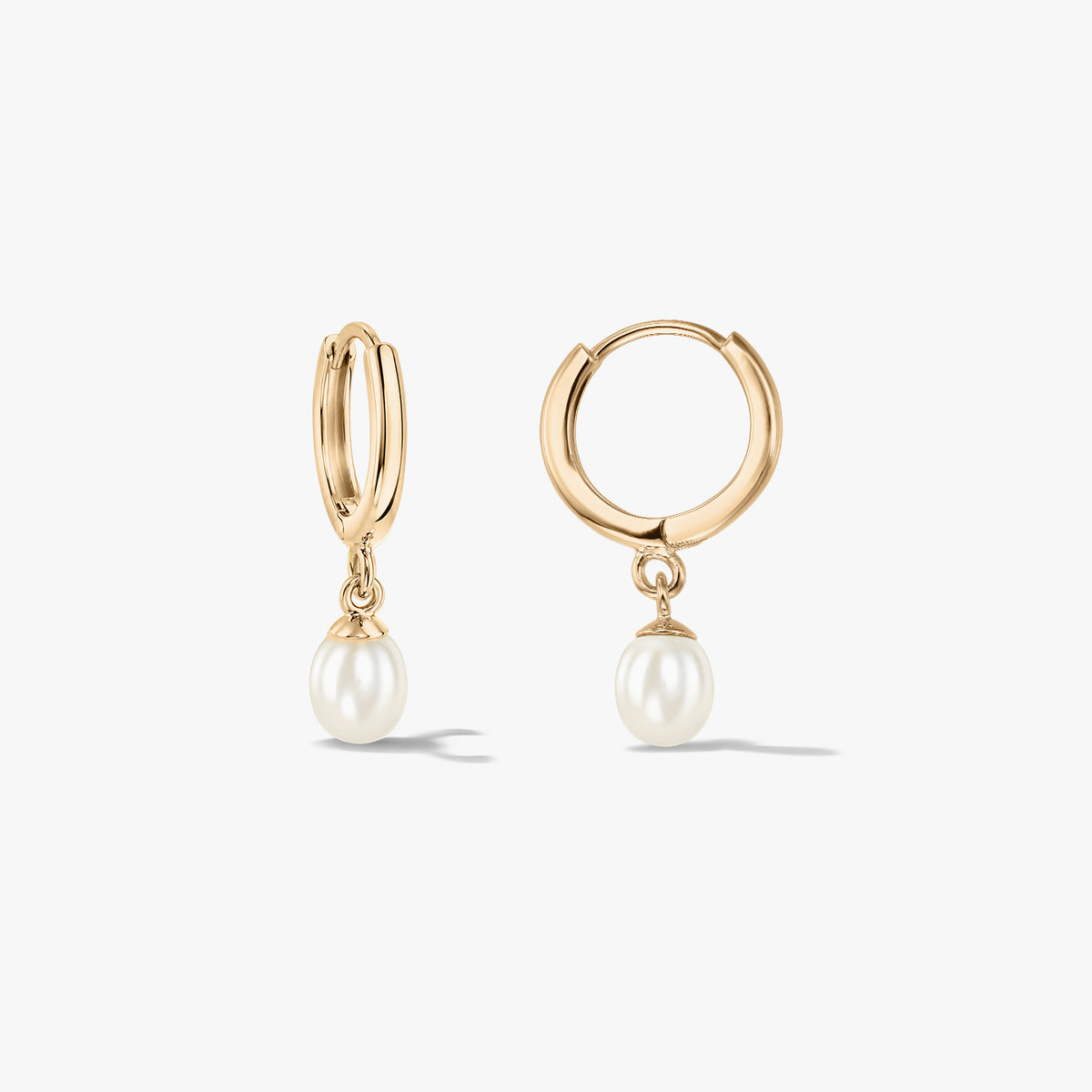 Pair of 14K yellow gold hoop earrings with natural pearl drops on a white background.