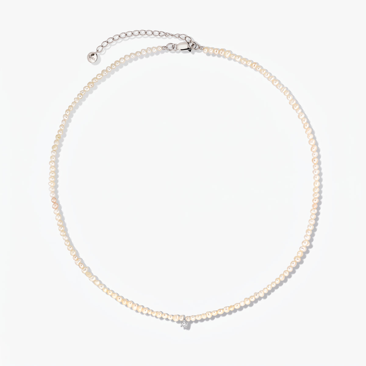Fairy silver necklace with small cultured pearls and an adjustable extender chain, photographed on a white background.