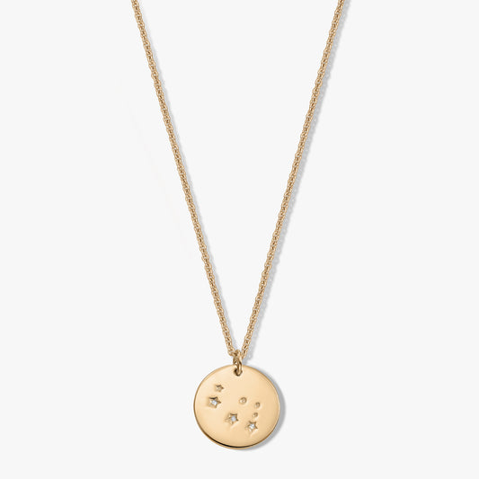 Dainty sterling silver Gemini zodiac disc pendant necklace with white sapphire on a white background.