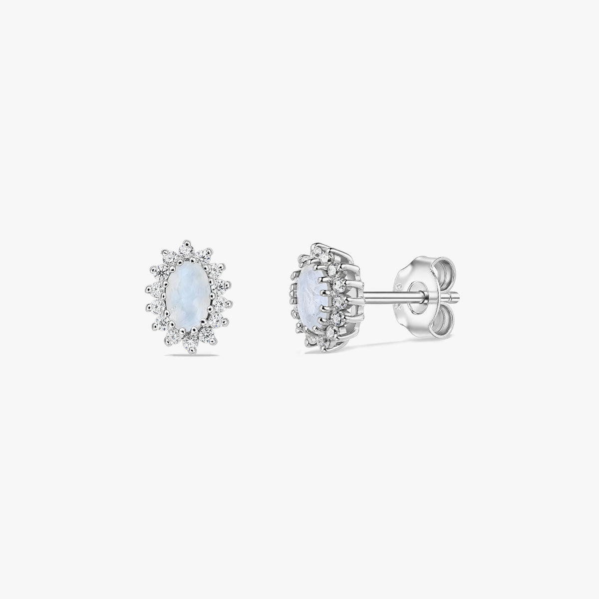 Pair of sterling silver moonstone halo stud earrings on a white background, shown in front and side views with oval cabochon centers and butterfly backs.