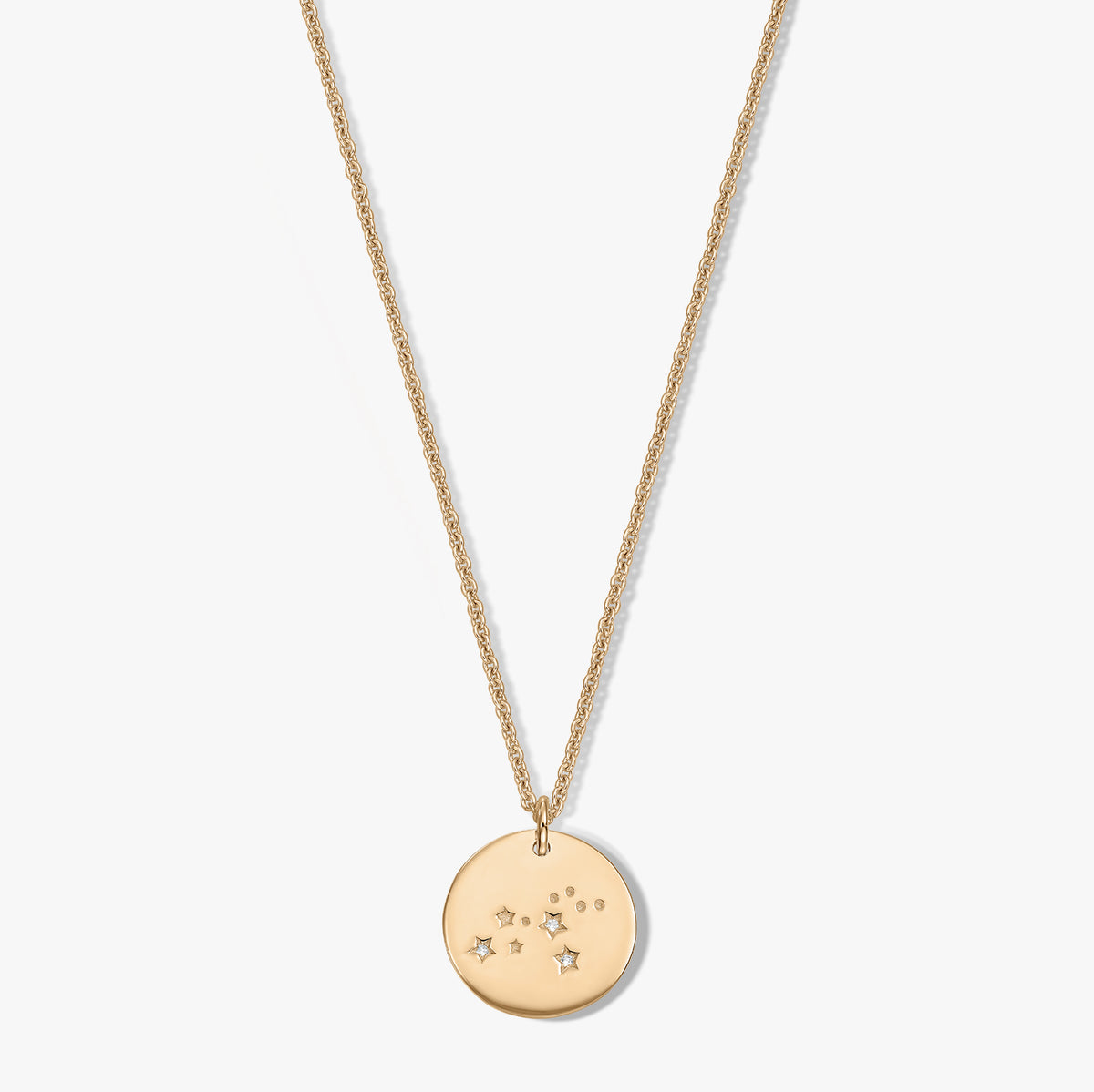 Golden Zodiac – Leo round disc pendant necklace with small star and dot accents set with white sapphires on a delicate chain, isolated on a white background.