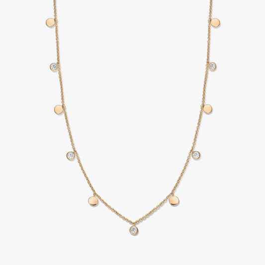 Gold‑plated sterling silver station necklace with alternating small polished disc charms and bezel‑set white topaz on a delicate chain, photographed on a white background.