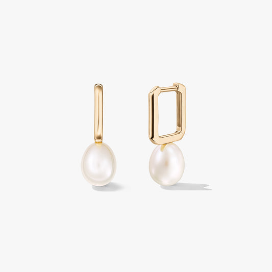 Gold-plated sterling silver huggie earrings with white natural pearl drops, one shown open to display the rectangular clasp, on a white background.