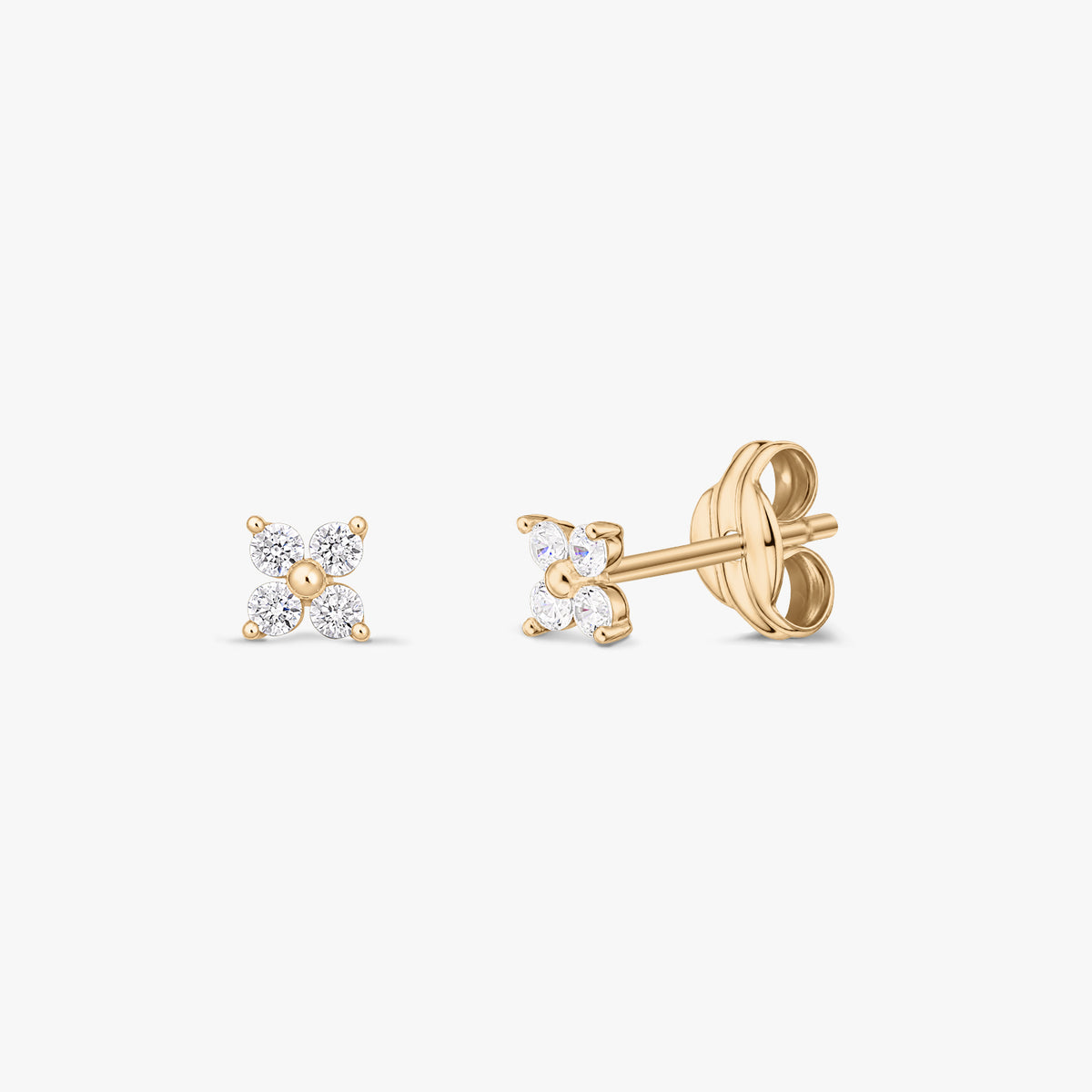 Pair of 14K yellow gold stud earrings with four clear zirconia stones in a petite flower shape, shown front and side on a white background.