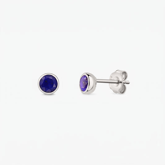 Sterling silver stud earrings with round faceted lapis lazuli stones; one earring shown front-facing and the other in side view with butterfly back on a white background.
