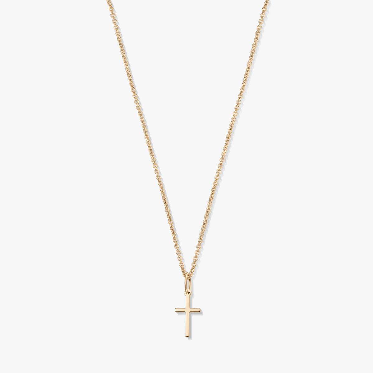 Minimalist 14K yellow gold necklace with a small cross pendant on a fine chain, isolated on a white background.