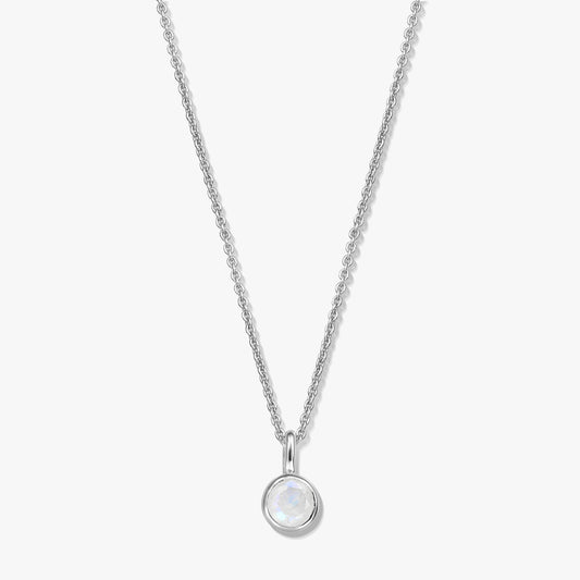 Sterling silver birthstone necklace with a round bezel-set moonstone pendant on a fine chain, photographed on a white background.