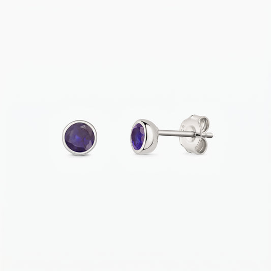 Silver bezel-set sapphire stud earrings, shown front and side on a white background.