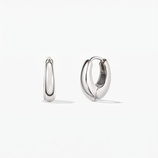 Pair of polished mini dome silver huggie hoop earrings on a white background, shown in front view and one open to reveal the hinged clasp.