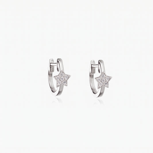 Pair of rhodium-plated 925 sterling silver huggie hoop earrings with small star charms set with clear zirconia on a white background.