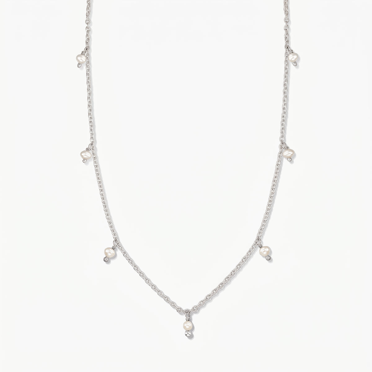 Indira Margot silver necklace with small natural pearl drops, photographed on a clean white background.